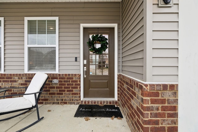 doorway to property with brick siding