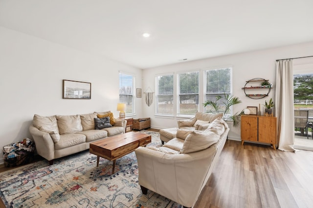 living area with baseboards and wood finished floors