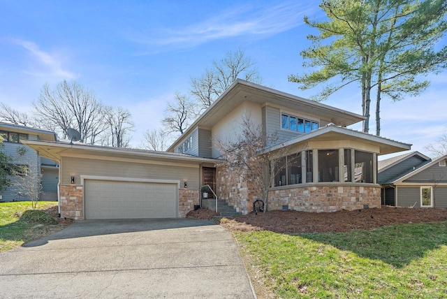 view of front facade with concrete driveway, a garage, and a sunroom