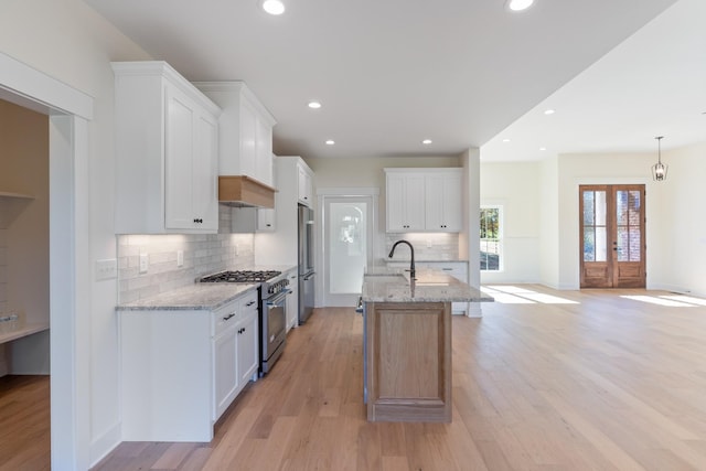 856 Tucker Rd, Dickson, TN 37055 - kitchen with high quality appliances, decorative backsplash, light stone counters, light wood-type flooring, and recessed lighting