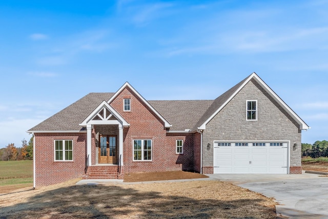 view of front of home featuring brick siding, stone siding, concrete driveway, and a shingled roof