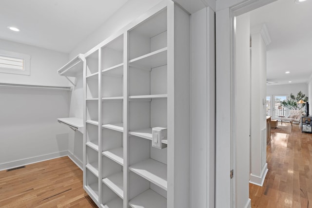 walk in closet featuring hardwood / wood-style floors and visible vents