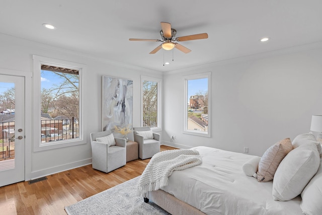 bedroom featuring access to exterior, visible vents, crown molding, multiple windows, and wood finished floors