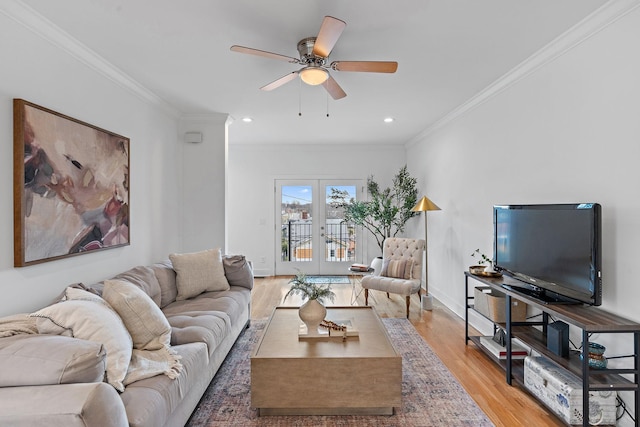 living area with a ceiling fan, baseboards, ornamental molding, french doors, and light wood-type flooring