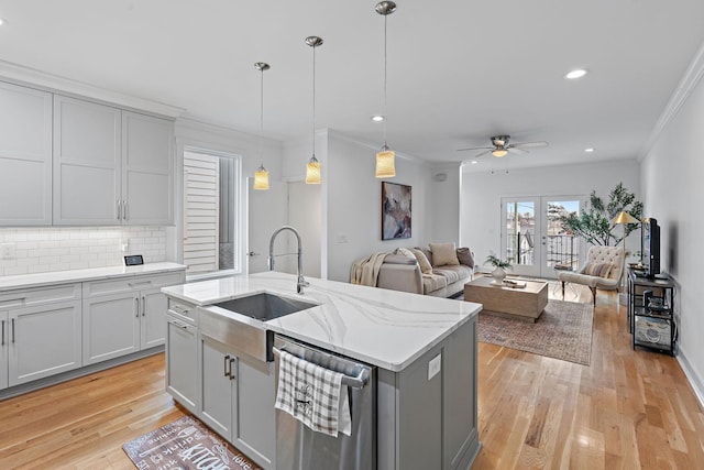 kitchen featuring dishwasher, light wood-style floors, gray cabinets, and a sink