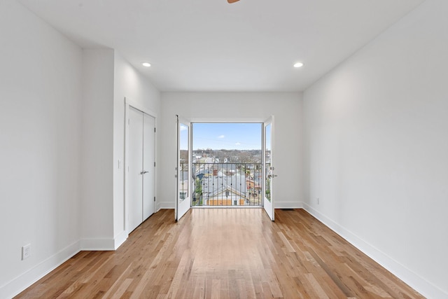 empty room with light wood finished floors, recessed lighting, and baseboards