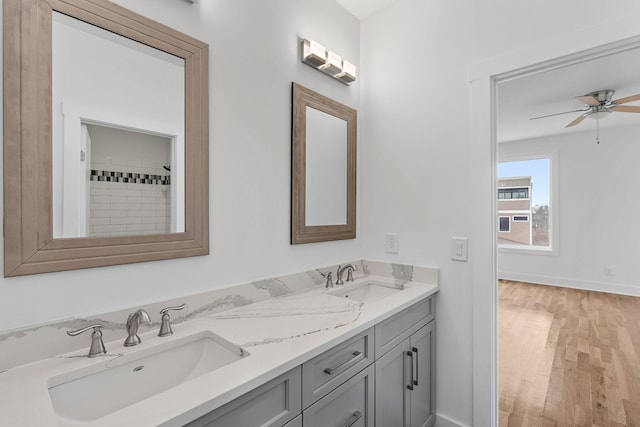 full bathroom with a sink, baseboards, wood finished floors, and a ceiling fan