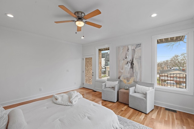 bedroom with visible vents, crown molding, light wood-type flooring, and baseboards