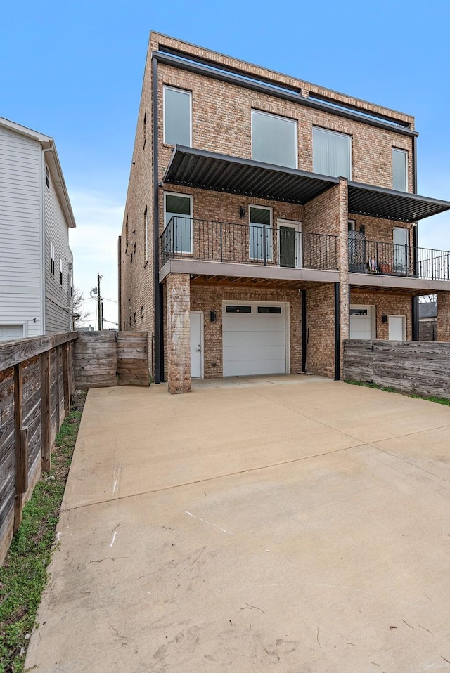 view of front of home featuring brick siding, driveway, a garage, and fence