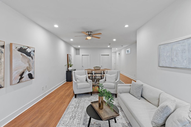 living room with visible vents, baseboards, light wood finished floors, recessed lighting, and ceiling fan