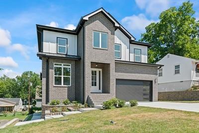 view of front facade with a front lawn, concrete driveway, and a garage