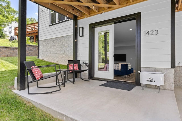 property entrance featuring a patio area and a yard