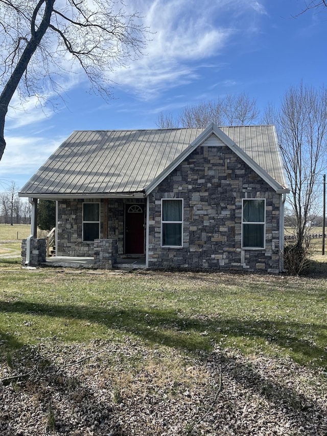 view of front of house with a front lawn, a porch, stone siding, and metal roof