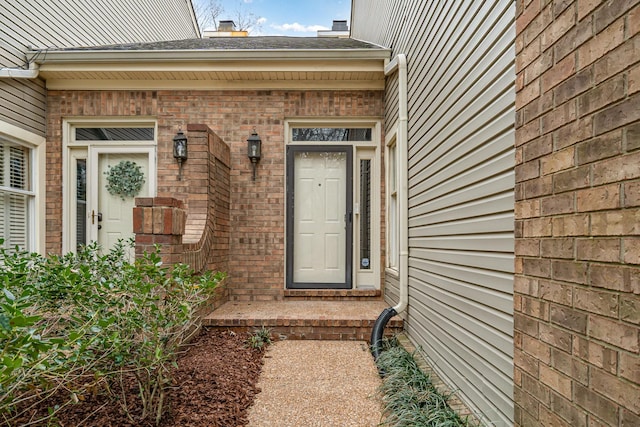 property entrance featuring brick siding