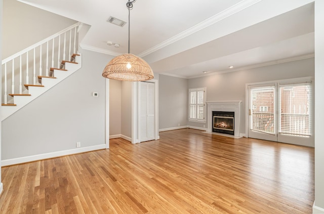 unfurnished living room featuring a wealth of natural light, visible vents, baseboards, and light wood-style floors