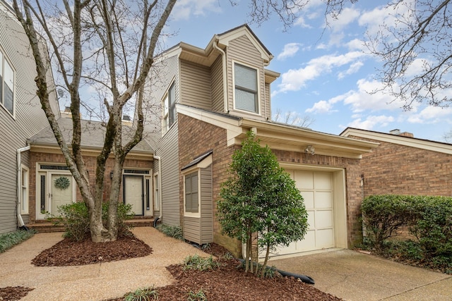 view of front of property featuring brick siding and concrete driveway