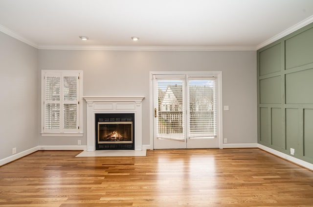 unfurnished living room featuring a fireplace with flush hearth, light wood-style flooring, and ornamental molding