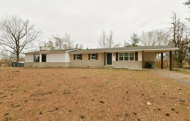 single story home featuring crawl space, a carport, and driveway