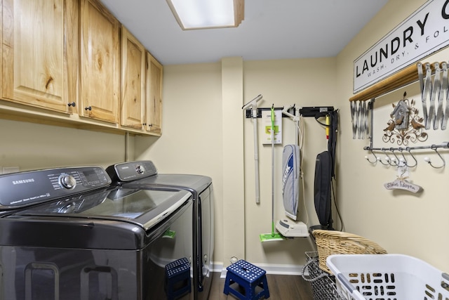 laundry room with cabinet space, washing machine and dryer, and dark wood-style flooring