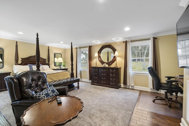 bedroom featuring multiple windows, wood finished floors, baseboards, and ornamental molding