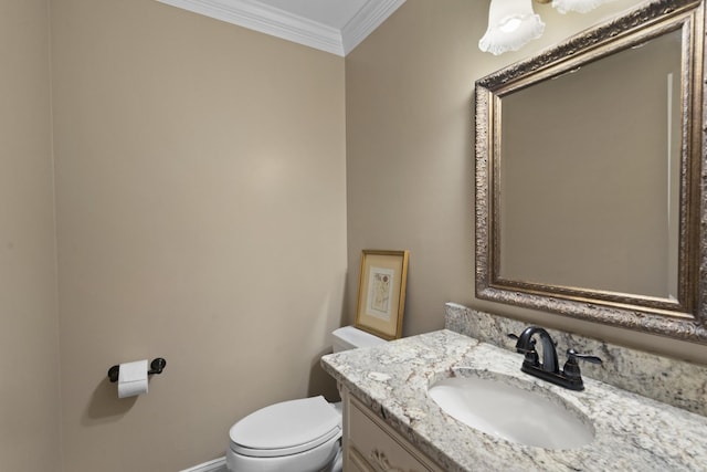 bathroom with vanity, toilet, baseboards, and ornamental molding