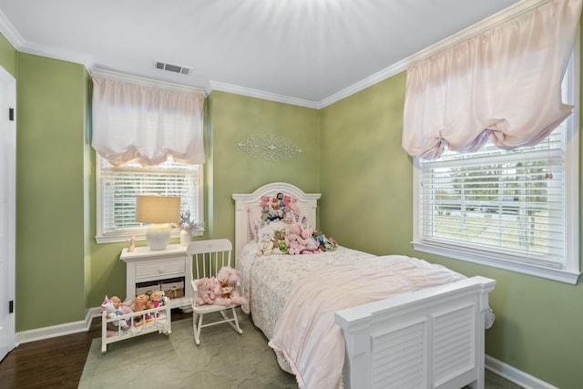 bedroom with visible vents, baseboards, wood finished floors, and ornamental molding