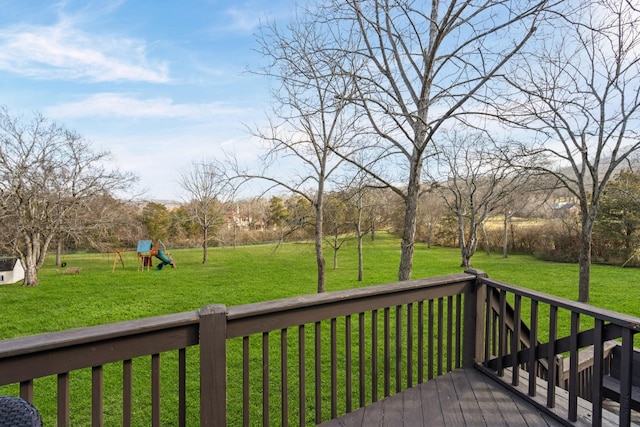 wooden deck with a playground and a lawn