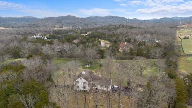 aerial view featuring a wooded view and a mountain view