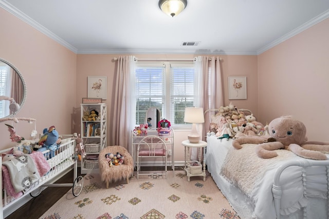 bedroom featuring visible vents, crown molding, and wood finished floors