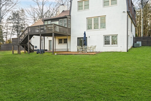 rear view of property featuring brick siding, central AC, a deck, and a chimney