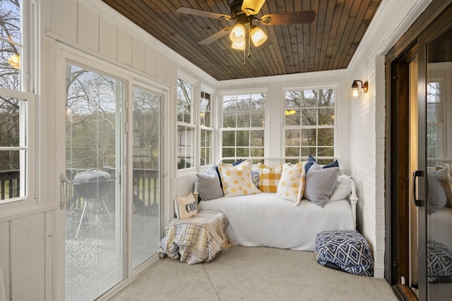 sunroom / solarium with a ceiling fan and wood ceiling