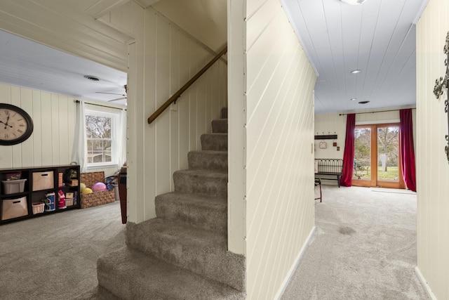 stairs with ceiling fan and carpet floors