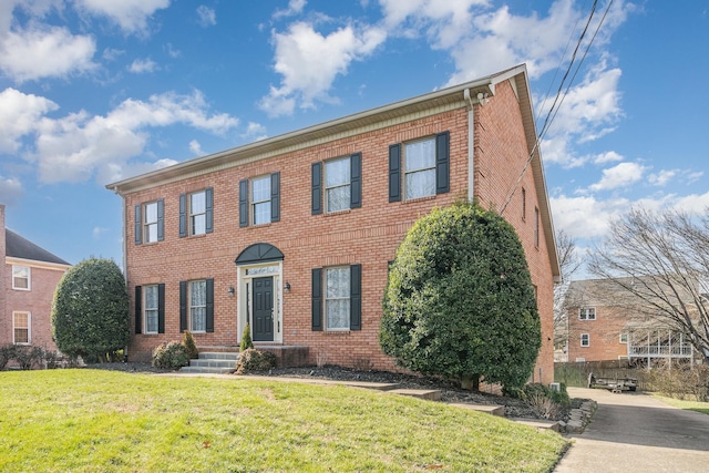 colonial-style house with brick siding and a front lawn