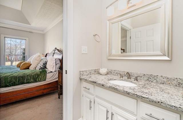 bathroom with vanity, ornamental molding, ensuite bathroom, and a textured ceiling