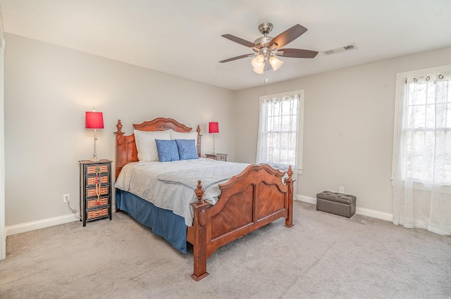 carpeted bedroom featuring baseboards, visible vents, and ceiling fan