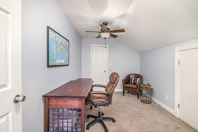 office area with ceiling fan, vaulted ceiling, carpet, and a textured ceiling