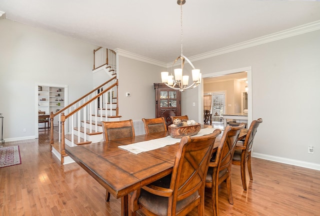 dining area with an inviting chandelier, stairway, baseboards, and light wood finished floors