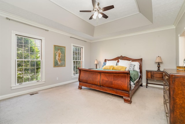 bedroom featuring baseboards, light carpet, a raised ceiling, and ornamental molding