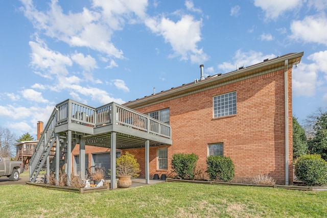 back of house featuring a yard, brick siding, a wooden deck, and stairway