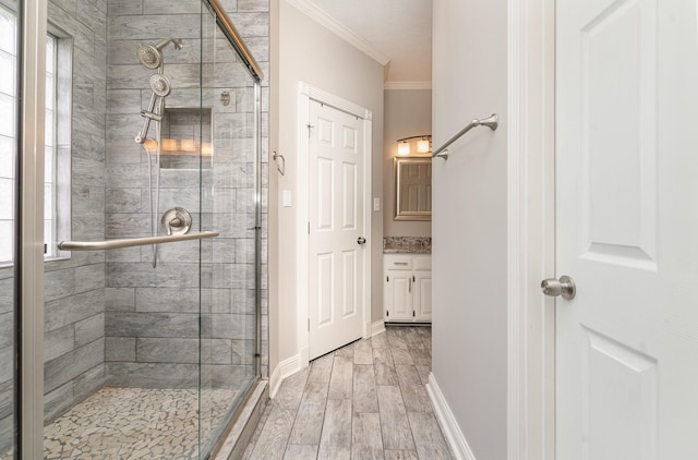 full bath with vanity, baseboards, wood tiled floor, a stall shower, and ornamental molding