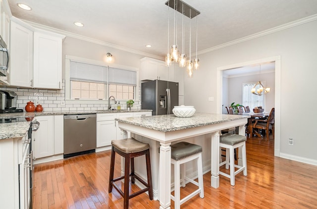 kitchen featuring a sink, tasteful backsplash, appliances with stainless steel finishes, and white cabinetry