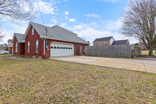 view of home's exterior with brick siding, fence, concrete driveway, a yard, and an attached garage