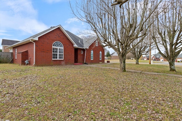 view of front of home featuring a front lawn and brick siding