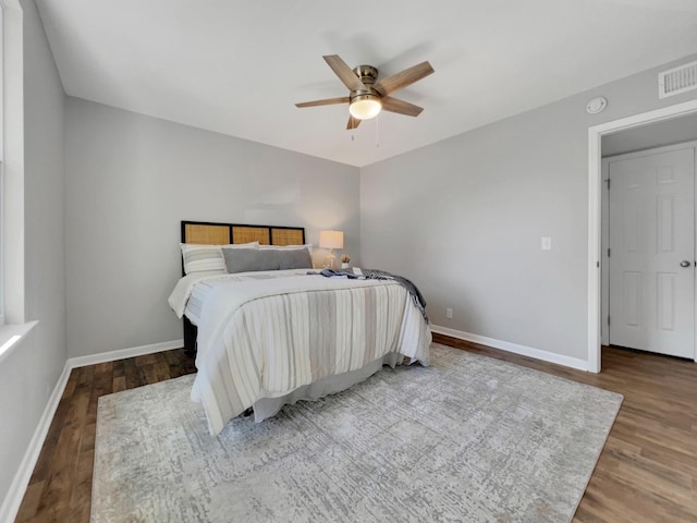 bedroom featuring visible vents, ceiling fan, baseboards, and wood finished floors