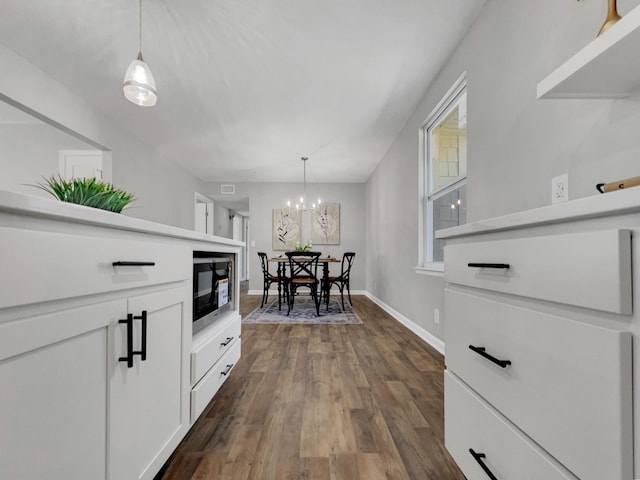 dining room featuring visible vents, a notable chandelier, dark wood-style floors, and baseboards