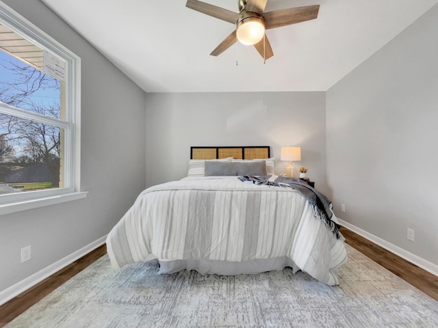 bedroom with wood finished floors, baseboards, and ceiling fan