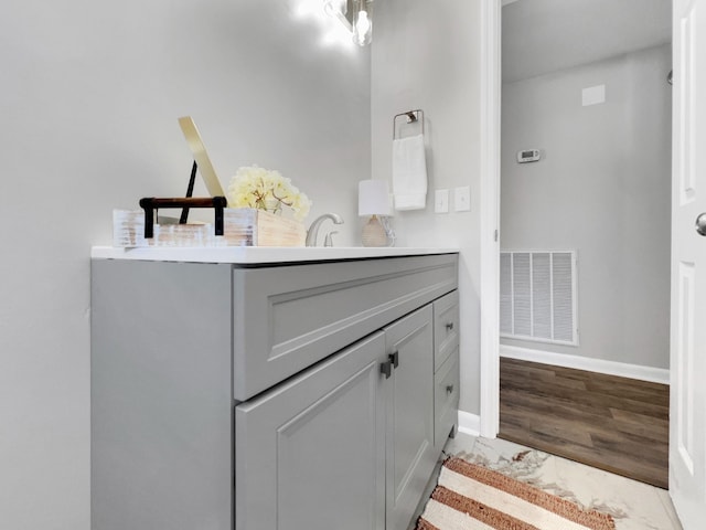 bathroom with visible vents, baseboards, wood finished floors, and vanity