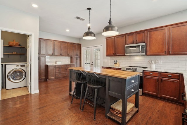 kitchen featuring visible vents, butcher block countertops, washer / dryer, french doors, and stainless steel appliances