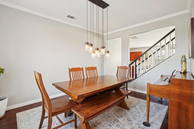 dining space featuring stairway, ornamental molding, baseboards, and wood finished floors