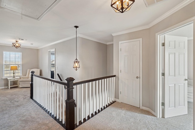 hall featuring visible vents, attic access, carpet, and ornamental molding